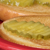 Closeup of dill pickle slices on a bun